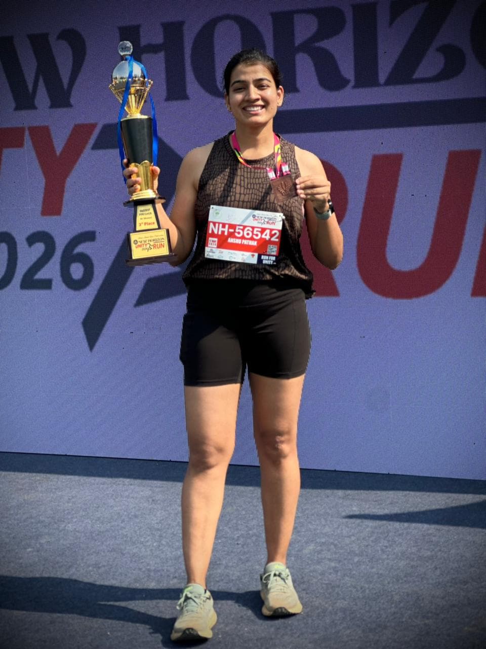 Anshu Pathak with the Fastest Finisher 3rd place trophy at New Horizon Silver Jubilee Run 2026