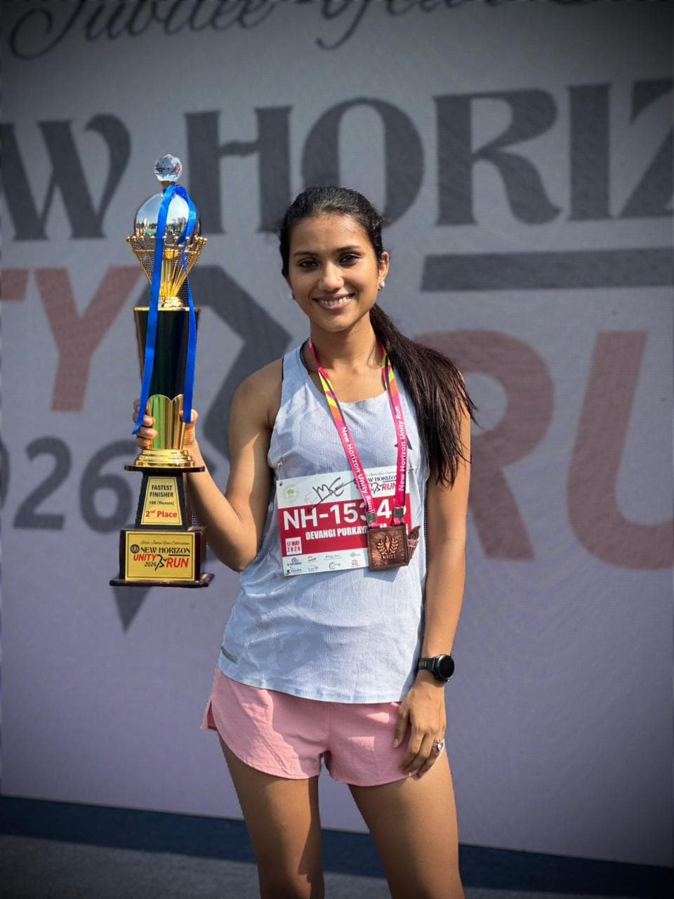Devangi Purkayastha with the Fastest Finisher 2nd place trophy at New Horizon Silver Jubilee Run 2026