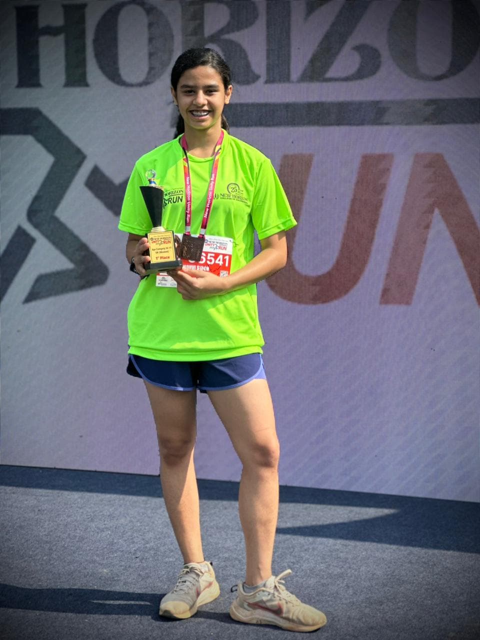 Young Runpundit athlete with her 1st place 5K Girls trophy at New Horizon Silver Jubilee Run 2026