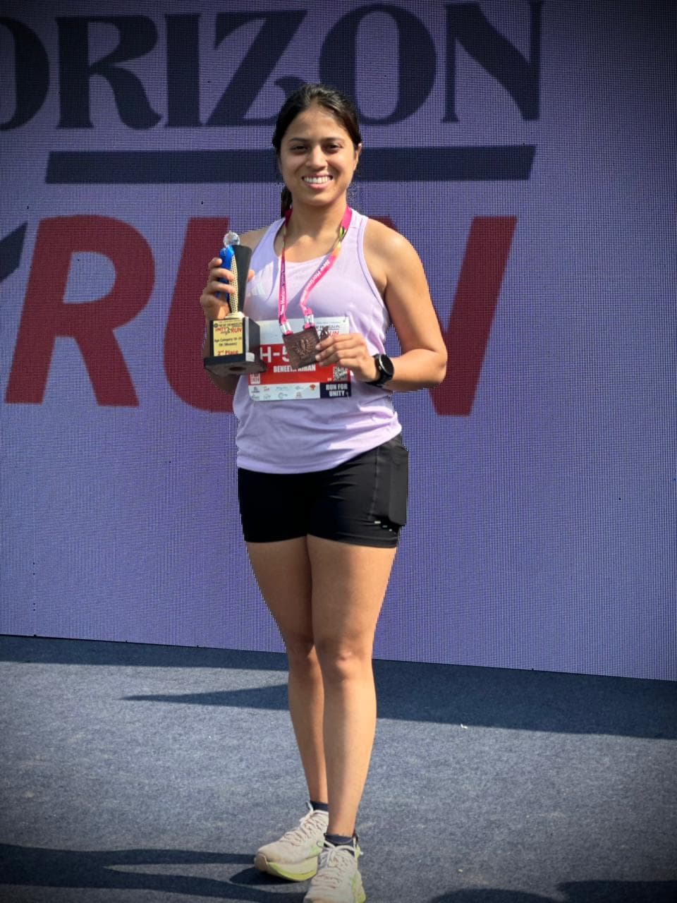 Runpundit athlete with her trophy and medal at New Horizon Silver Jubilee Run 2026