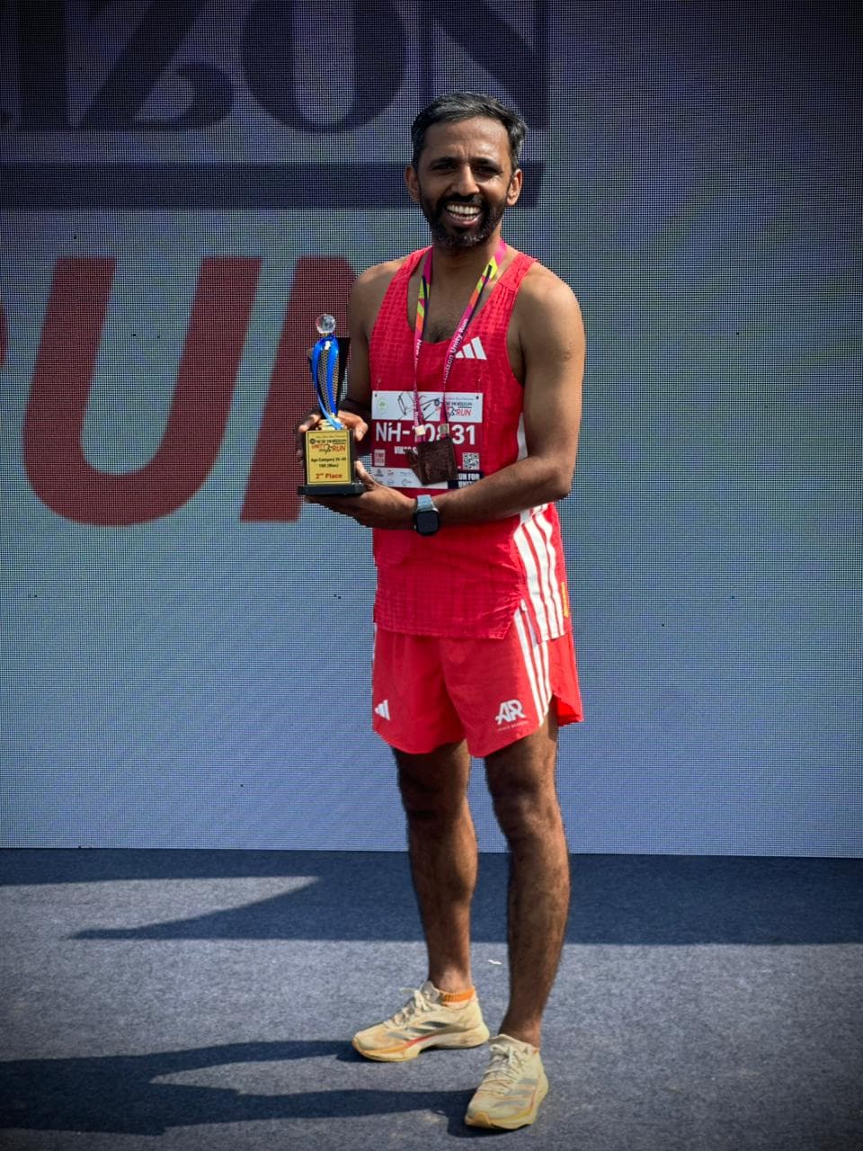 Coach Vikas Srinivasan with his 2nd place trophy at New Horizon Silver Jubilee Run 2026
