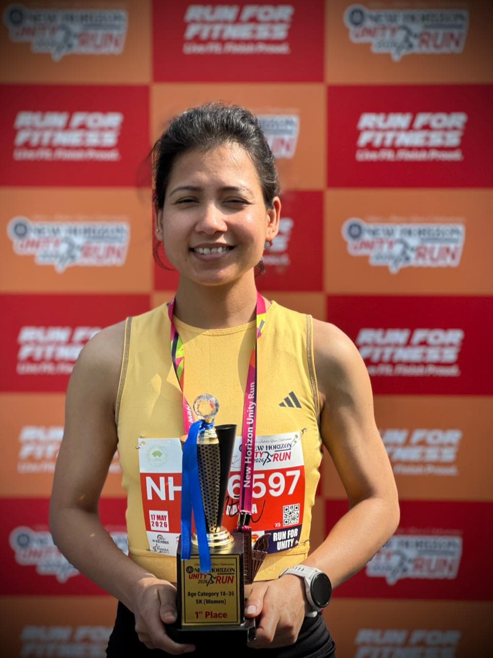 Runpundit athlete with her 1st place 5K Women trophy at New Horizon Silver Jubilee Run 2026